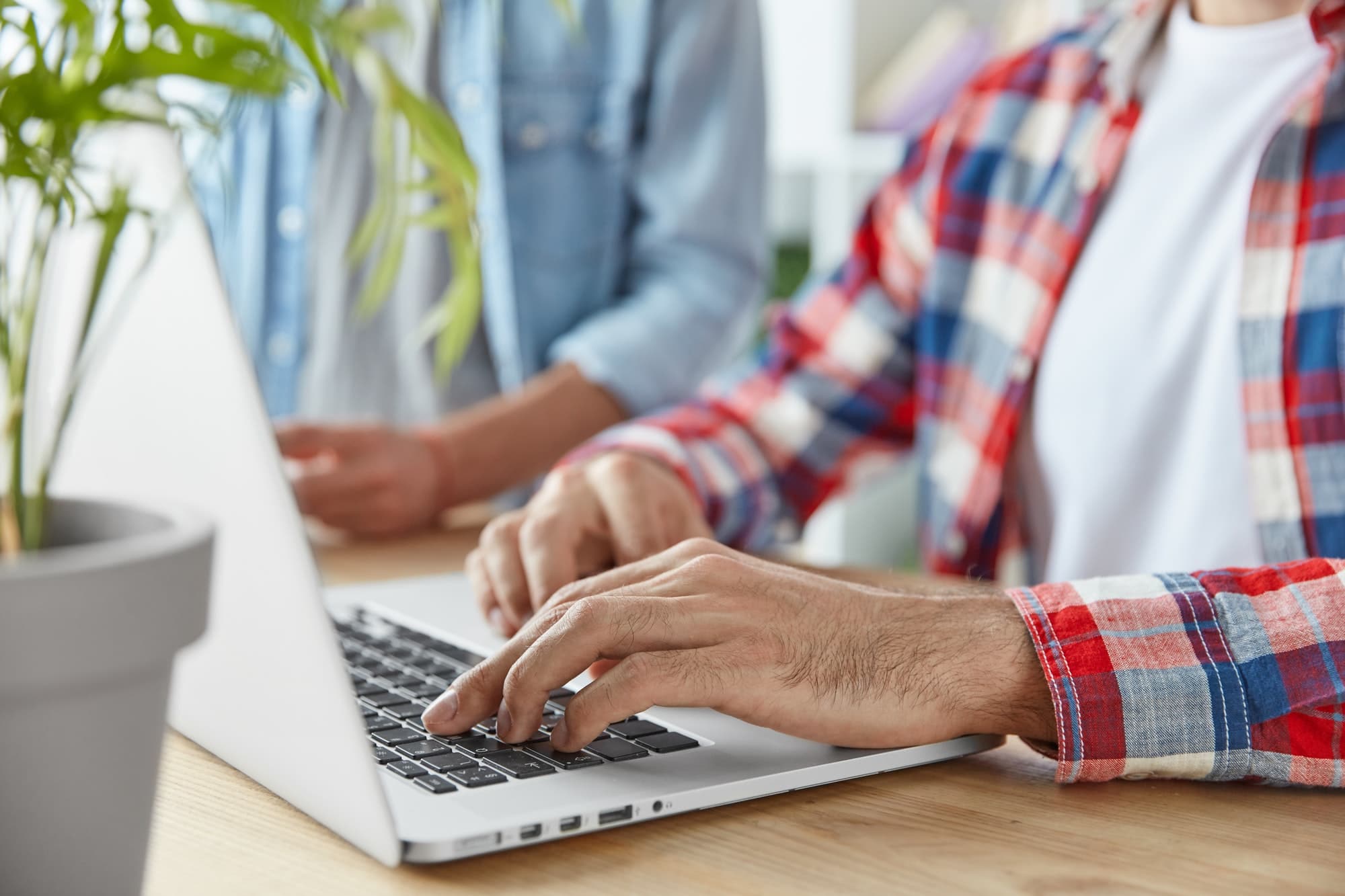 cropped-shot-of-two-male-bloggers-type-publication-on-laptop-computer-use-laptop-computer-sit-at-w